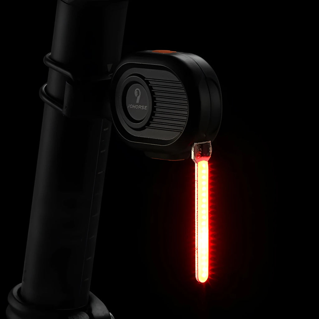Blue LED waterfall effect bicycle rear safety light with USB Type-C charging port on a black background.