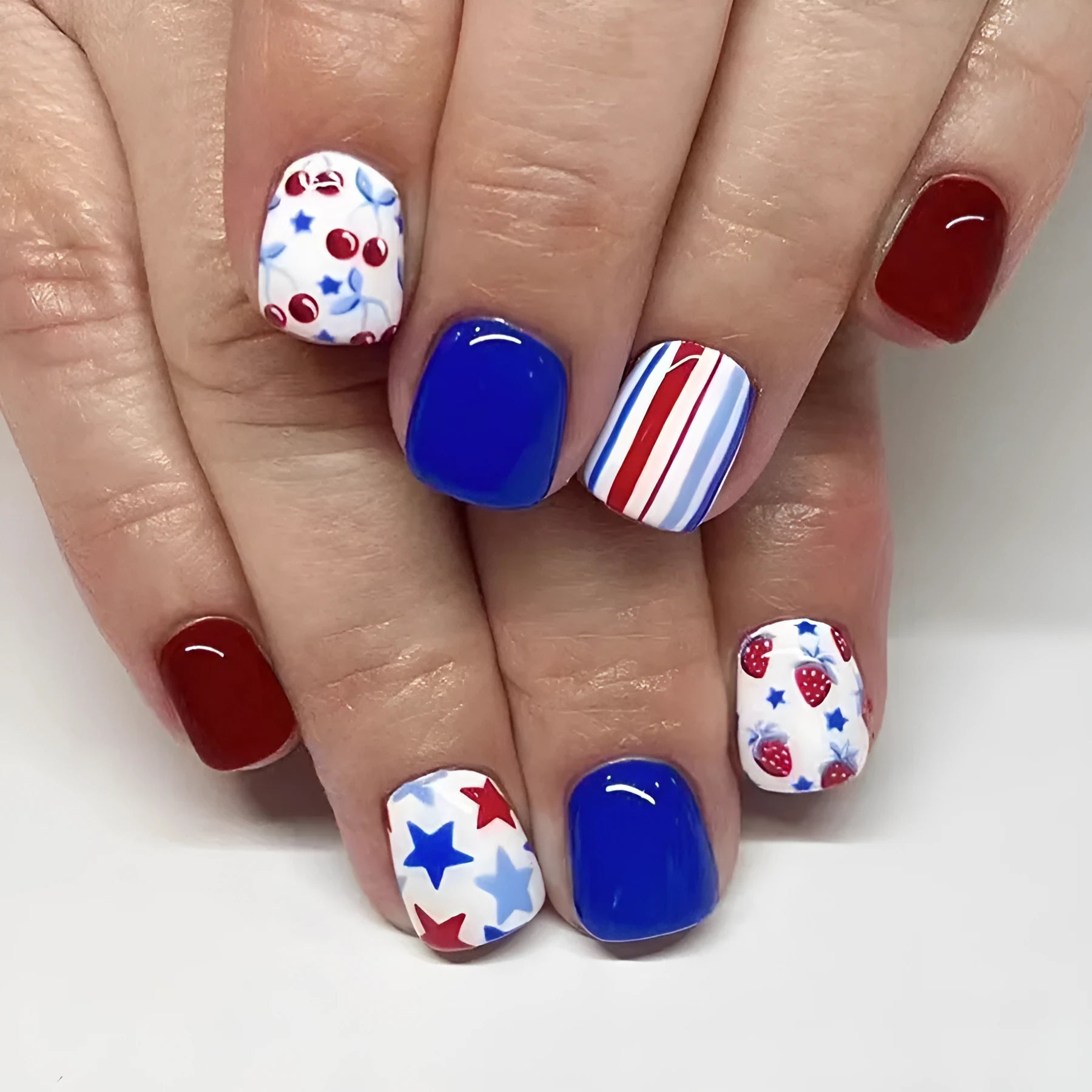 Short glossy red and blue strawberry cherry false nail stickers Independence Day themed 24 piece set.