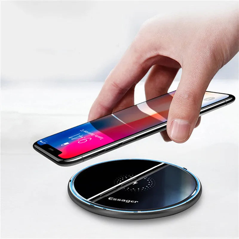 Black Qi fast wireless charging pad for smartphones on a desk