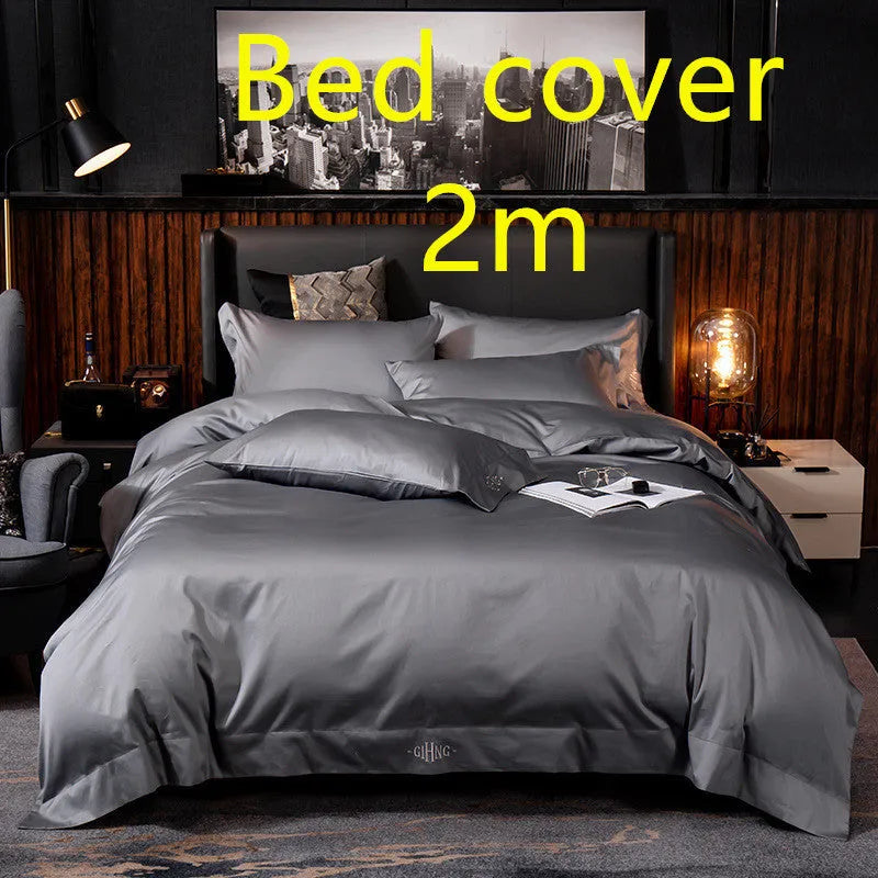 Four-piece cotton satin quilted bedding set with duvet cover, sheet, and pillowcases in a bedroom setting
