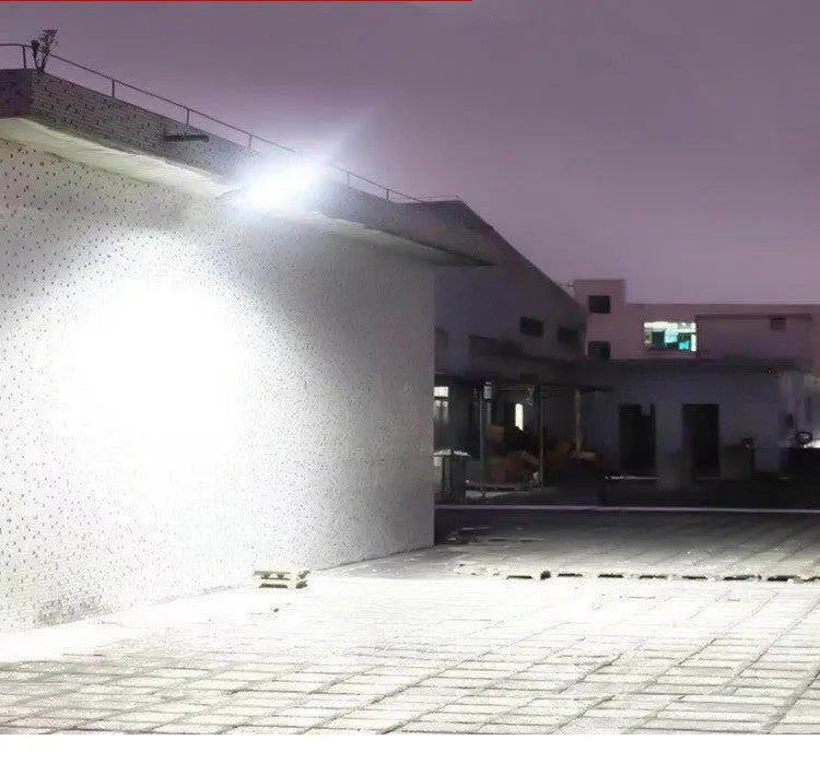 Black solar-powered outdoor motion sensor light mounted on a wall.