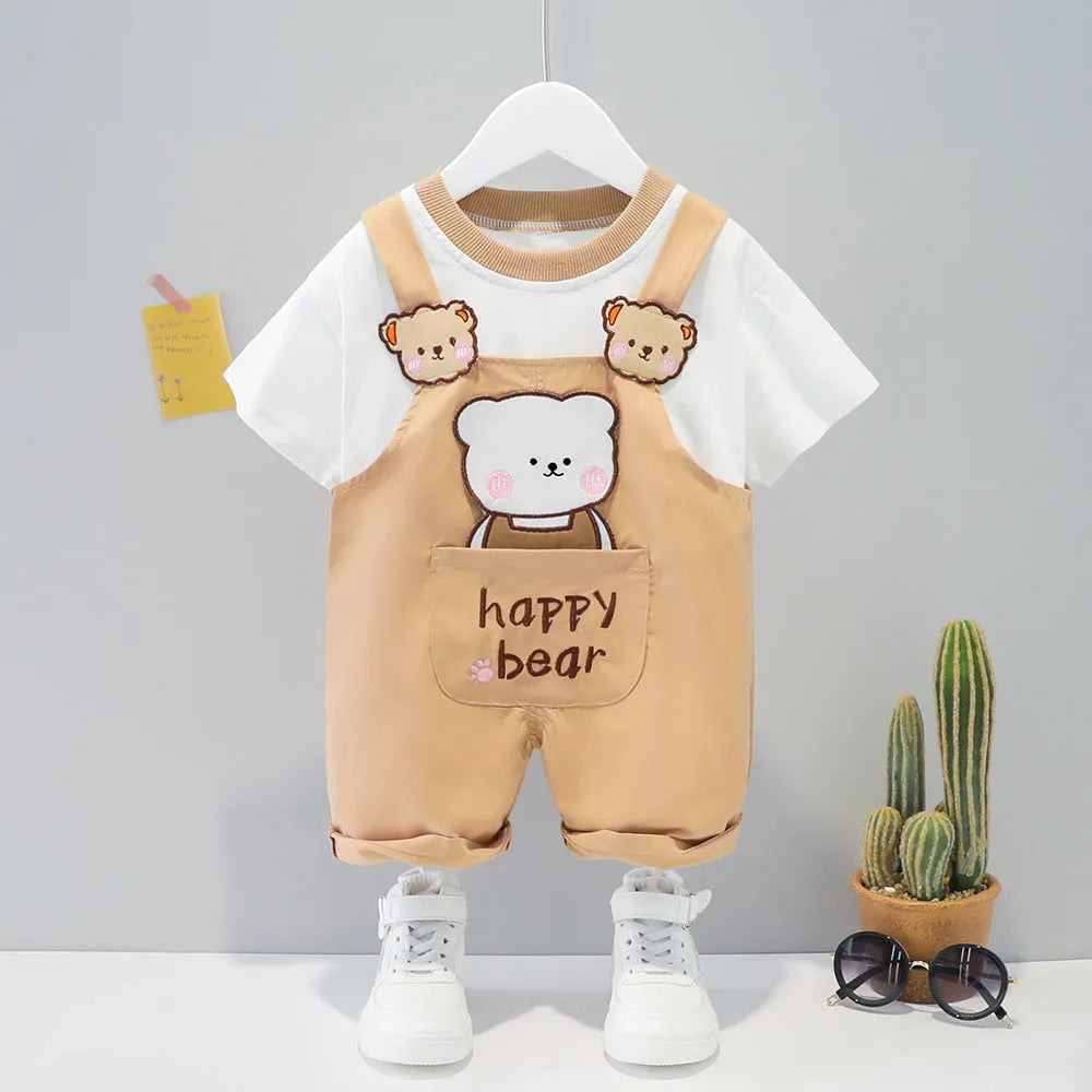Baby wearing yellow cotton short-sleeved overalls with cartoon design and adjustable straps.