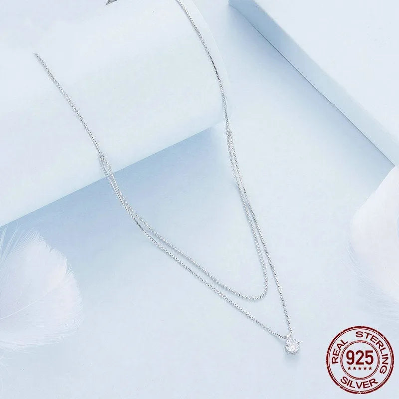 Close-up of a women's double-layer pearl chain sterling silver necklace with a matching pendant.