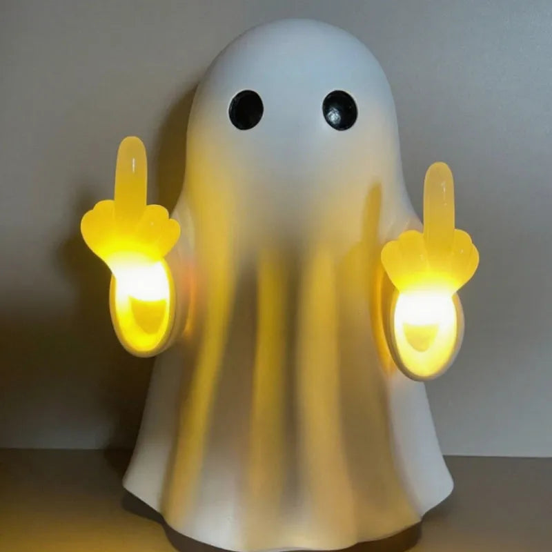 Small white ghost statue night lamp on a shelf for Halloween decor.
