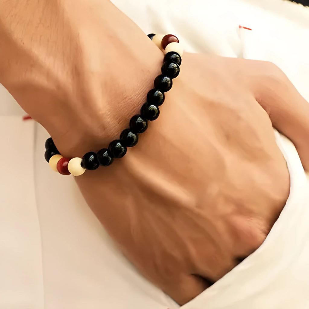 A natural lava stone bead bracelet with an ethnic design on a wrist, showing its porous texture for essential oils.