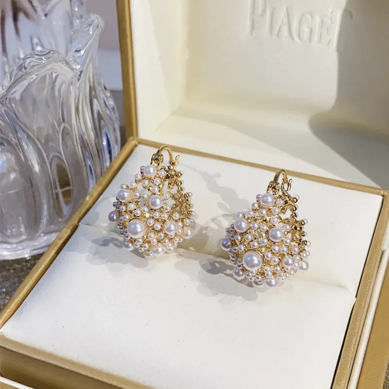 Gold-coloured copper flower basket earrings with small pearl-inlaid beads.