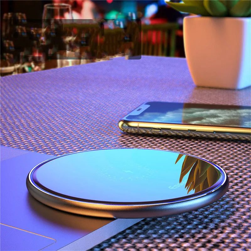 Black Qi fast wireless charging pad for smartphones on a desk