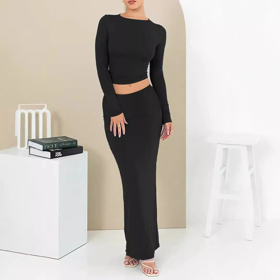 Women's black two-piece suit set with three-quarter sleeve top and long skirt on a mannequin.