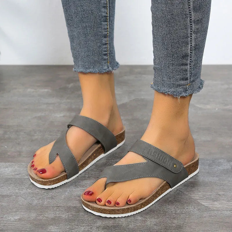 A pair of thick-soled flat toe ring flip flops in a solid colour, showing the foam sole and artificial PU upper.