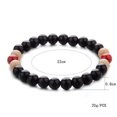 A natural lava stone bead bracelet with an ethnic design on a wrist, showing its porous texture for essential oils.