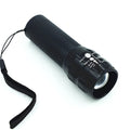 Black mini LED flashlight with telescopic head and tail push button switch on plain background