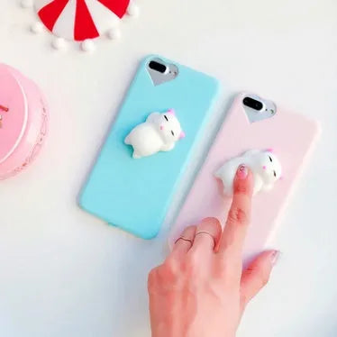 A soft pink silicone iPhone case with a raised 3D cartoon cat design on the back.