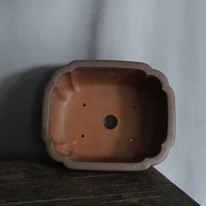 Purple sand rectangular ceramic bonsai pot on a flat surface.