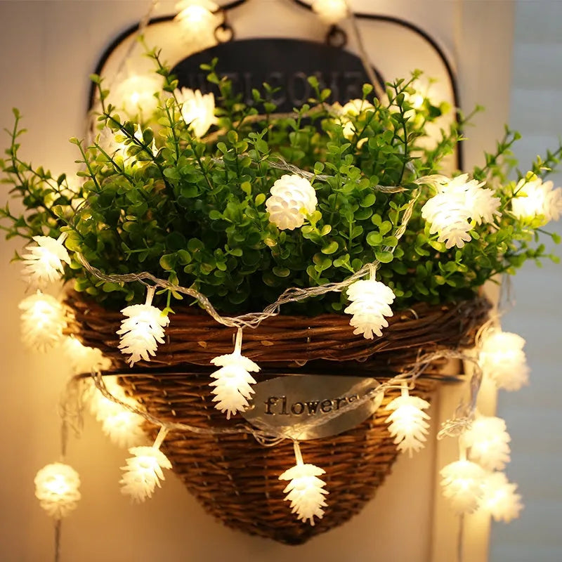 Warm white LED pine cone lights on a string, powered by batteries, for indoor and outdoor decoration.