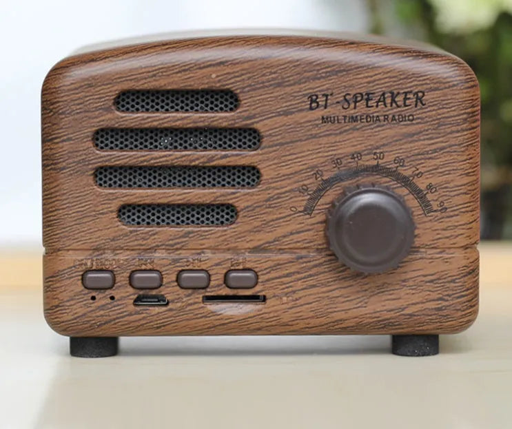 Vintage wood effect Bluetooth speaker in pink, black, and wood grain colour options showing compact 93x70x59mm size