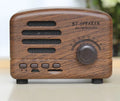 Vintage wood effect Bluetooth speaker in pink, black, and wood grain colour options showing compact 93x70x59mm size