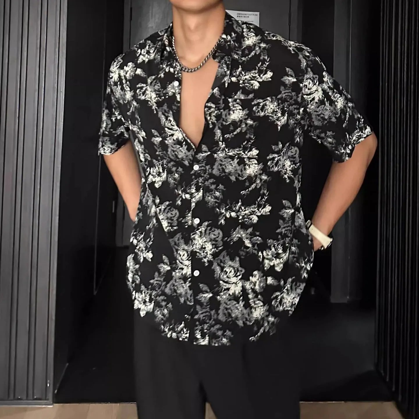 Loose black floral print short sleeve casual shirt on a hanger.