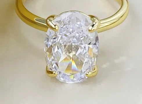 Gold or silver oval women's ring with a four-claw setting holding a hand-cut stone.