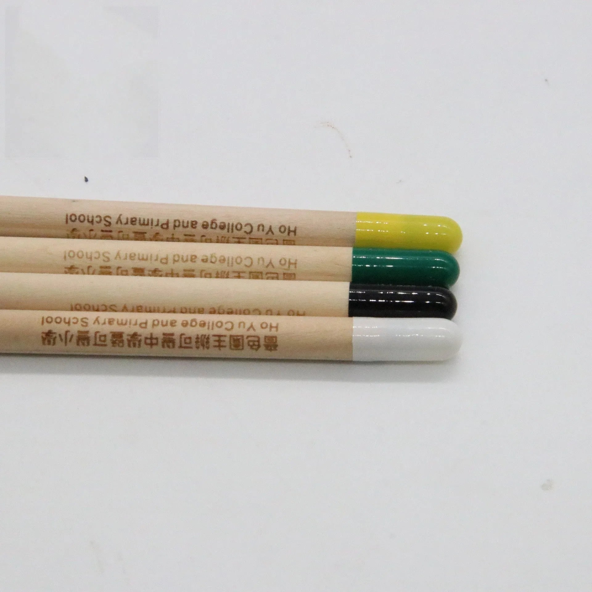 Seed pencil with coloured degradable capsule containing plantable seeds next to a small potted seedling.