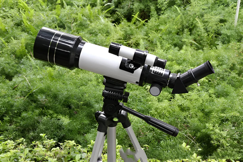 Dark blue children's astronomical telescope with monocular and tripod on a white background.