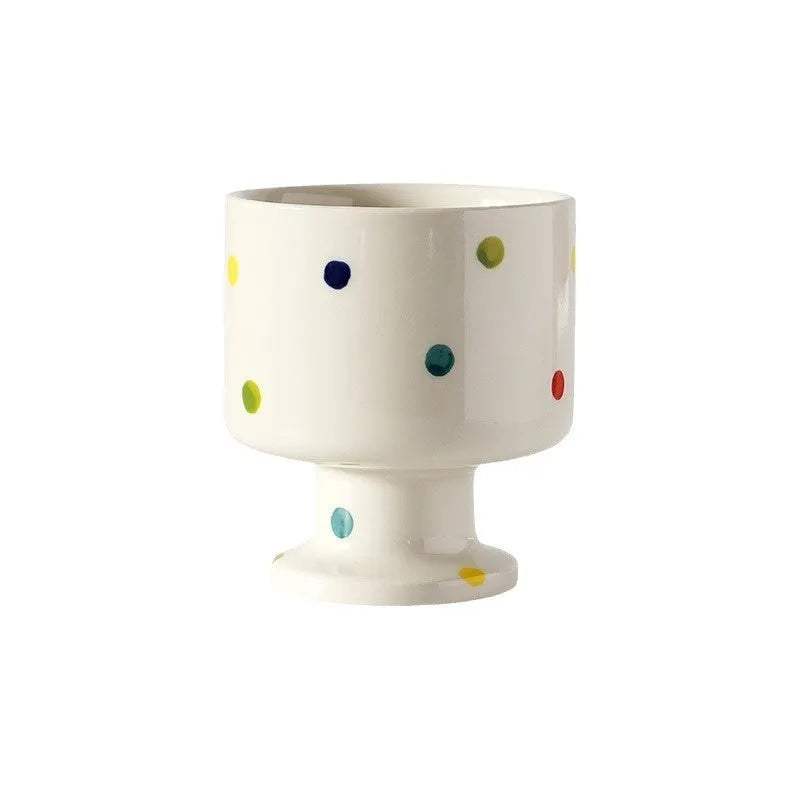 Handmade irregularly shaped ceramic mug in a solid colour, shown on a table.