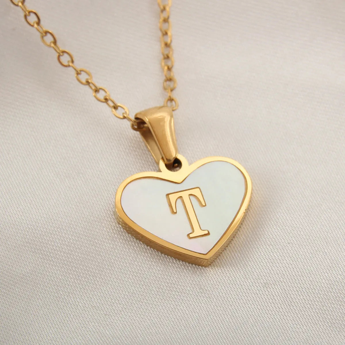 Gold plated chain necklace with a white shell heart-shaped pendant personalised with a single letter initial.