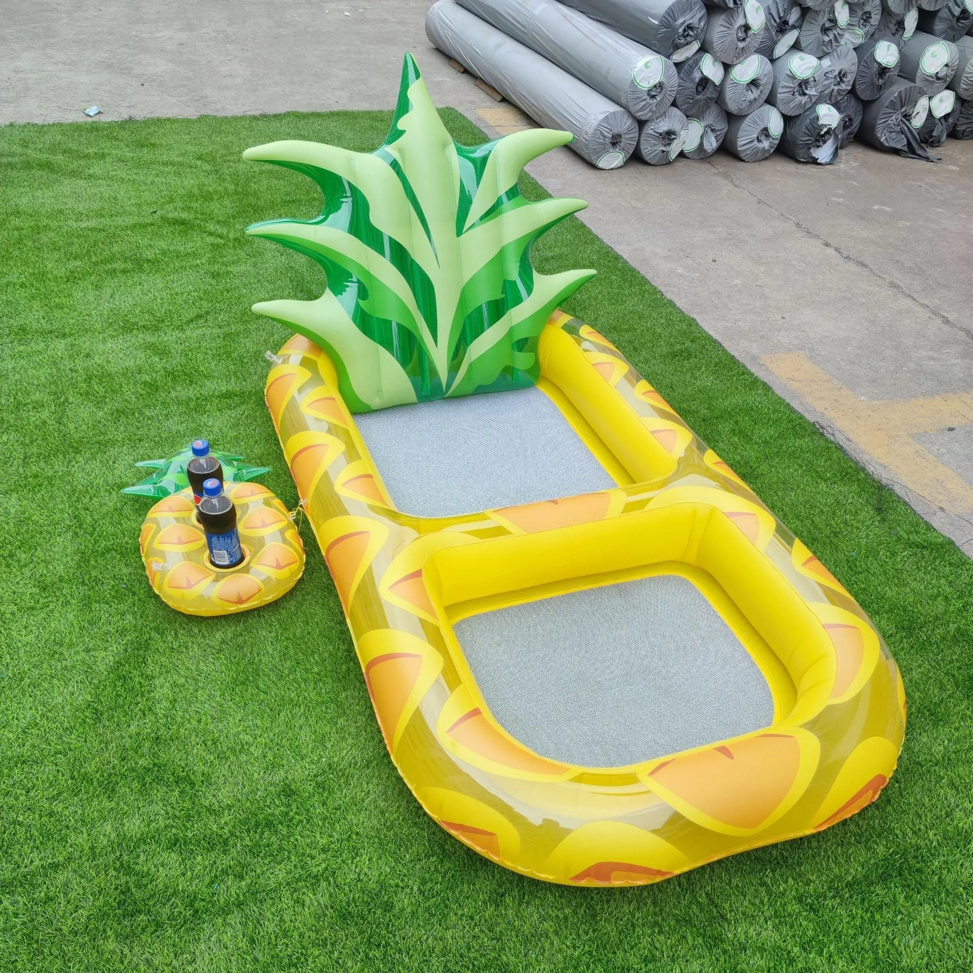 Inflatable pineapple pool lounger with cup holder floating on water in yellow colour