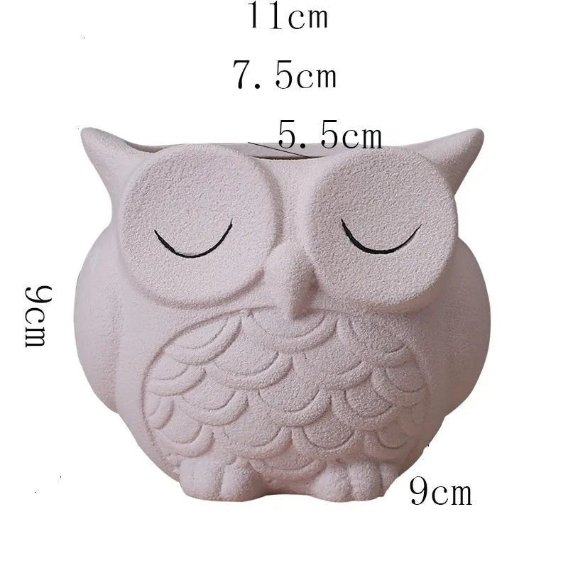 Handmade frosted ceramic owl succulent pot in pastel colour on a wooden surface.