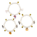 Three pearl and bell necklaces for pets laid out, suitable for cats and small dogs.