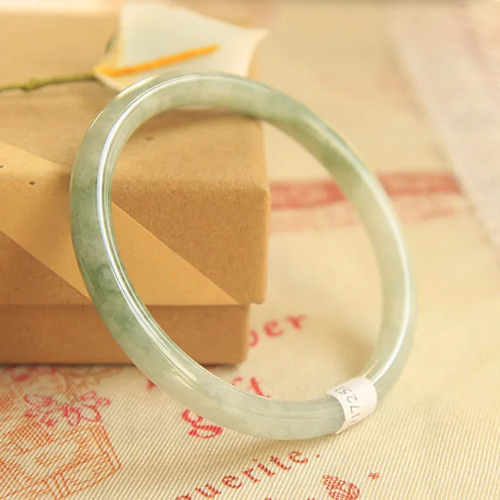 Green jade waxy student bracelet with geometric Chinese design showing adjustable sizing options