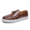 Men's black tassel detail slip-on sneakers with a round toe and rubber sole on a white background.