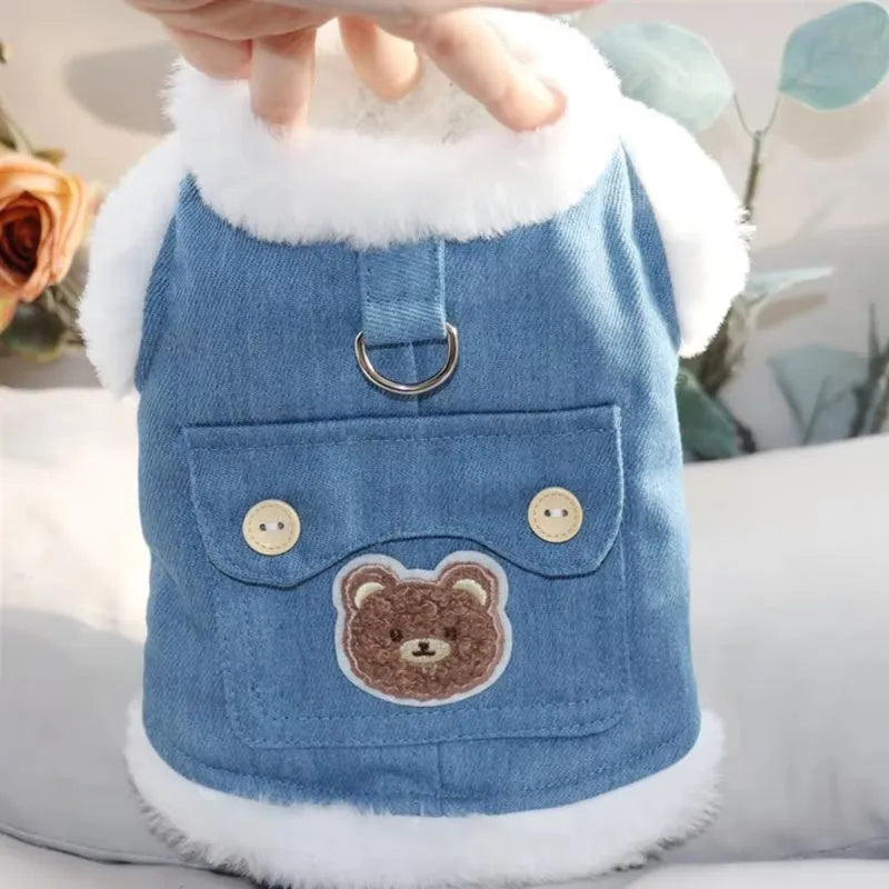 Denim blue pet vest with white wool lining, bear print, wooden buttons, and metal D-ring.