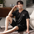 Man's light blue ice silk short-sleeve pajama shirt and matching loose shorts laid flat.
