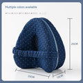 Heart-shaped dark blue jacquard memory foam leg pillow for adults on a bed.