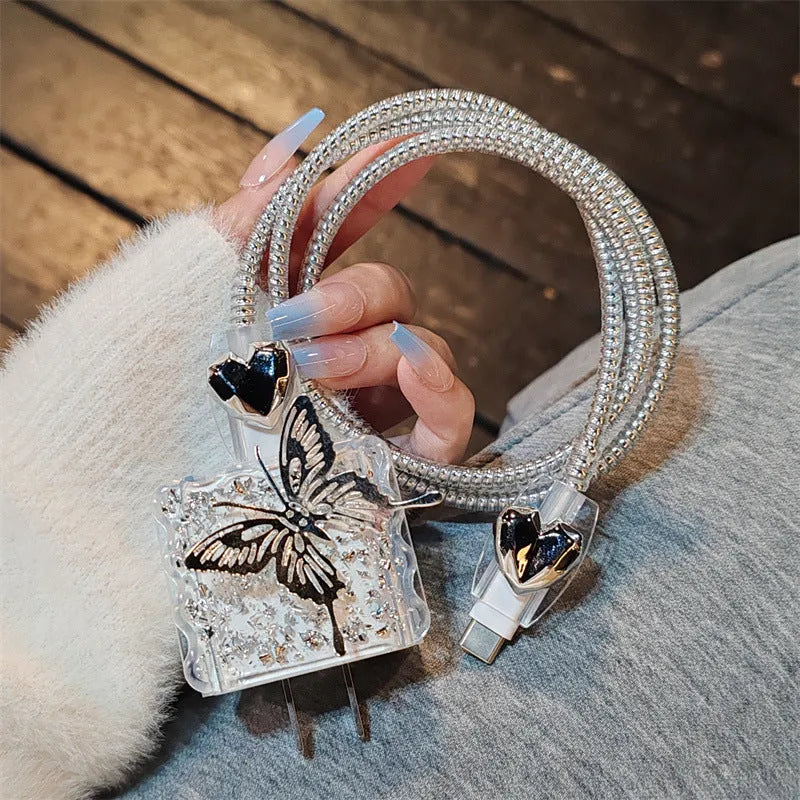 Three-dimensional butterfly USB cable protection sleeve in butterfly colour with silver foil finish on a white background