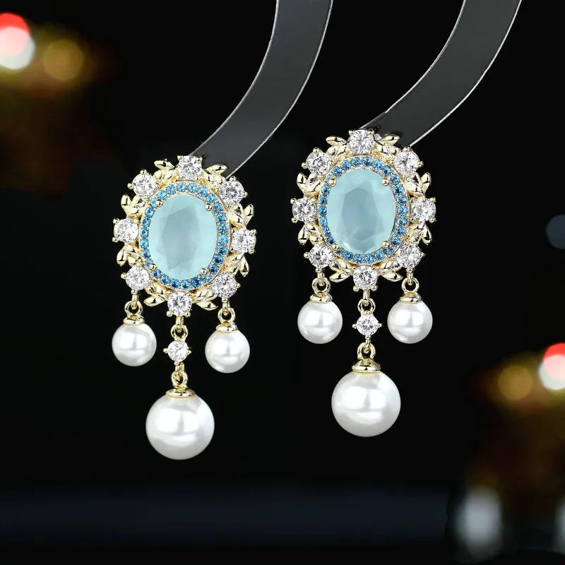 Oval geometric earrings with zircon inlay, pearl details, and tassel design in light purple colour