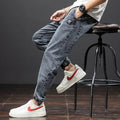 Men's loose blue cargo jeans with straight leg on a neutral background.