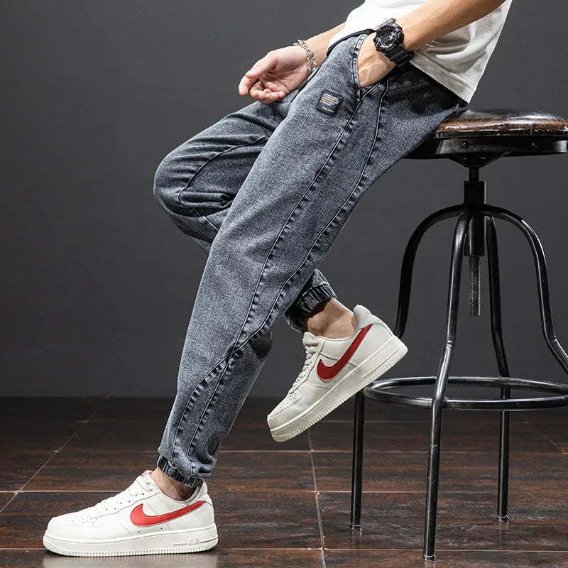 Men's loose blue cargo jeans with straight leg on a neutral background.