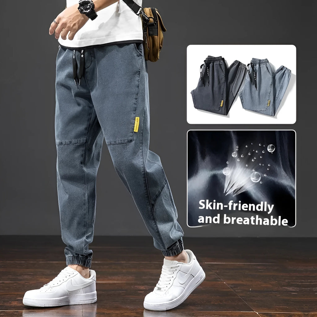 Men's loose blue cargo jeans with straight leg on a neutral background.