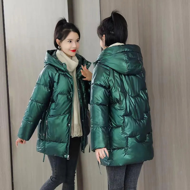 Green loose-fit hooded winter jacket for women on a hanger, showing long sleeves.