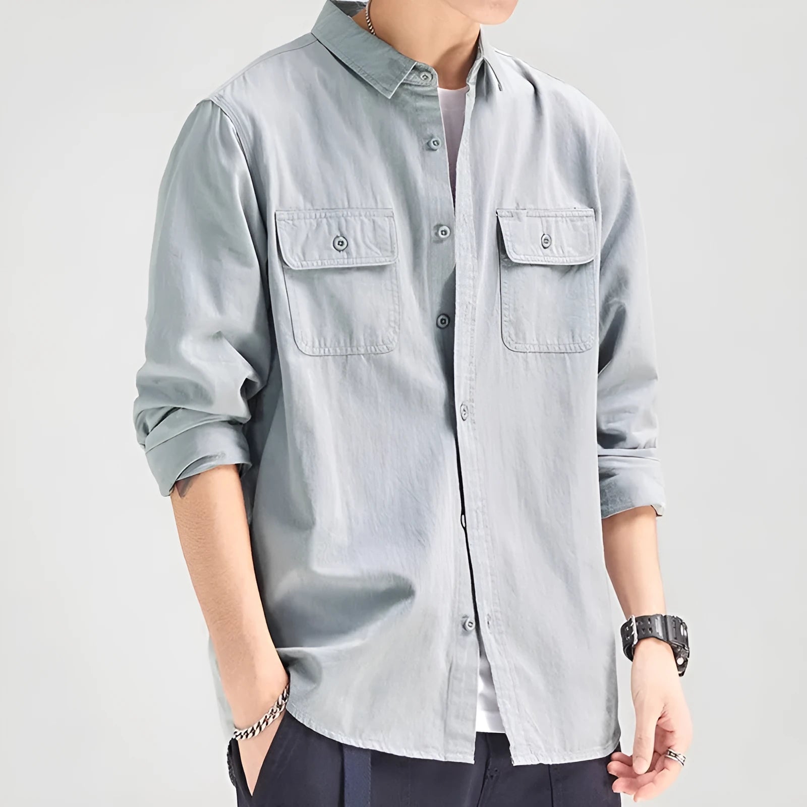 Man wearing a loose fit long sleeve cardigan shirt in light grey polyester.