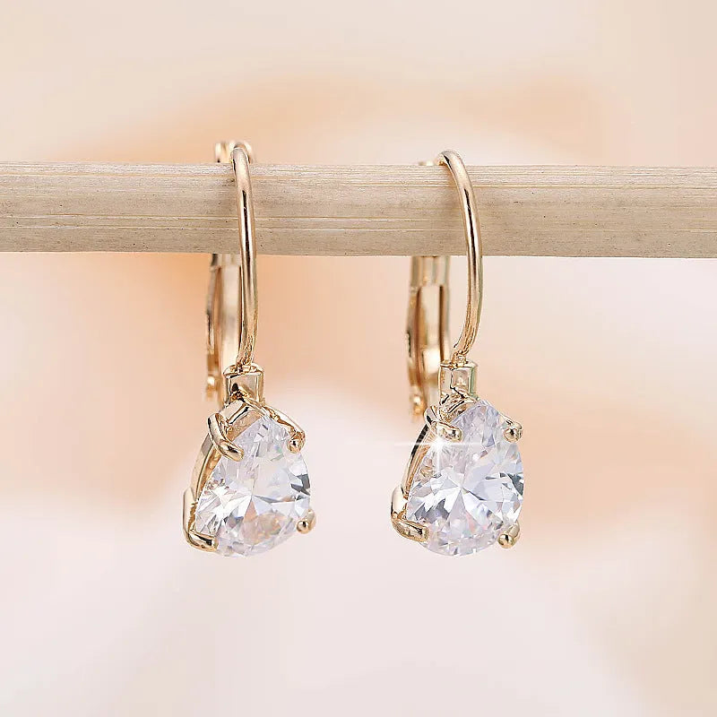 A pair of women's drop-shaped copper earrings with gemstone inlay, shown in gold and platinum colour options.