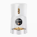 Black automatic pet feeder with digital display and food hopper on a floor