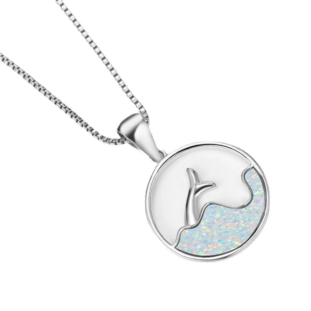 White gold geometric sea fishtail pendant necklace with a round blue opal stone on a chain.