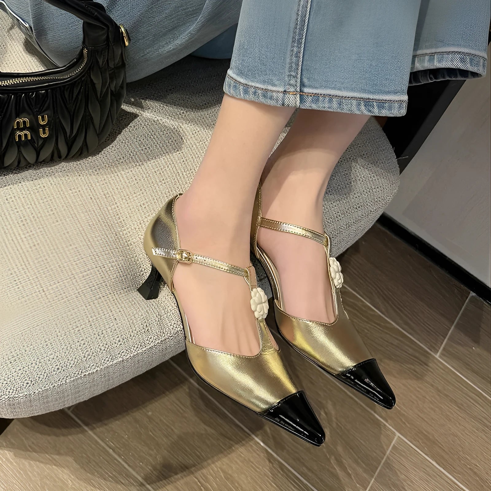 Women's black pointed toe stiletto shoe with flower buckle detail on a sheepskin upper.