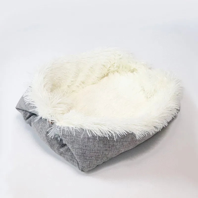 Grey fluffy pet sleeping pad for cats and dogs on a sofa, showing non-slip black bottom.