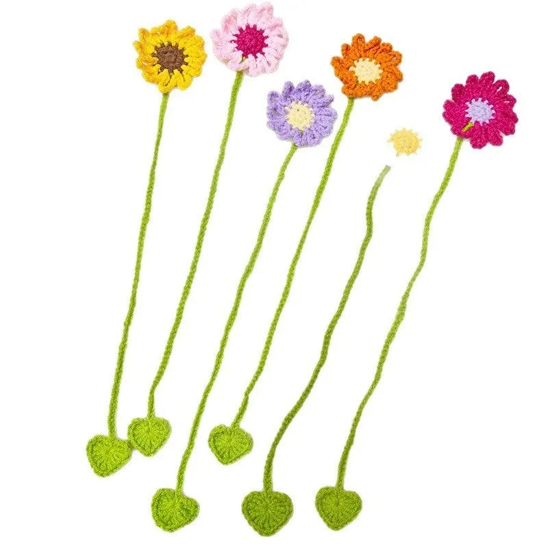 Hand-crocheted daisy wool bookmark with flexible wire core in yellow, pink, and light purple colours.