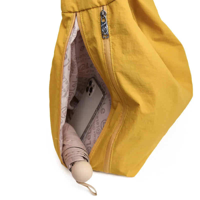 Soft heart-shaped nylon underarm bag for women in yellow, shown worn crossbody.