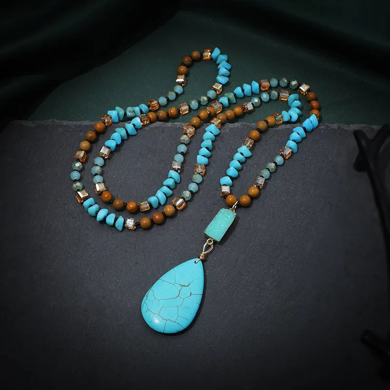 Turquoise blue large water drop pendant on a long mixed-material bead necklace.