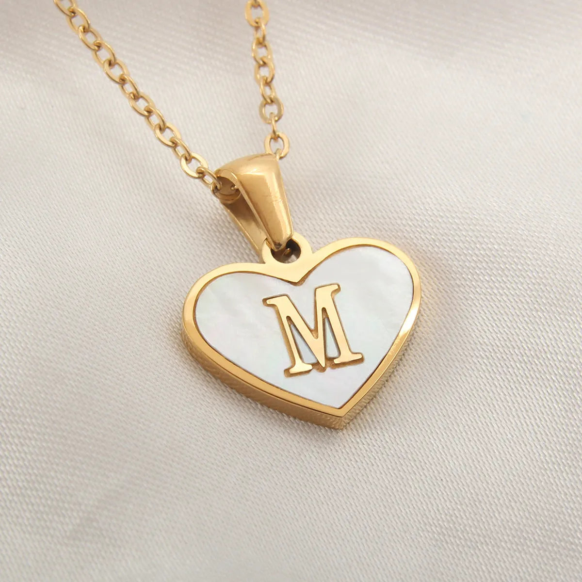 Gold plated chain necklace with a white shell heart-shaped pendant personalised with a single letter initial.